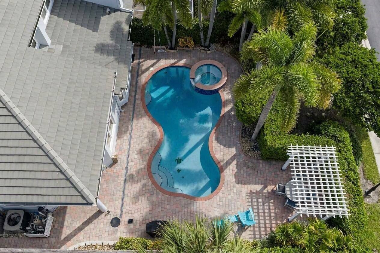 Private pool and spa from above with pavered patio, palms and pergola