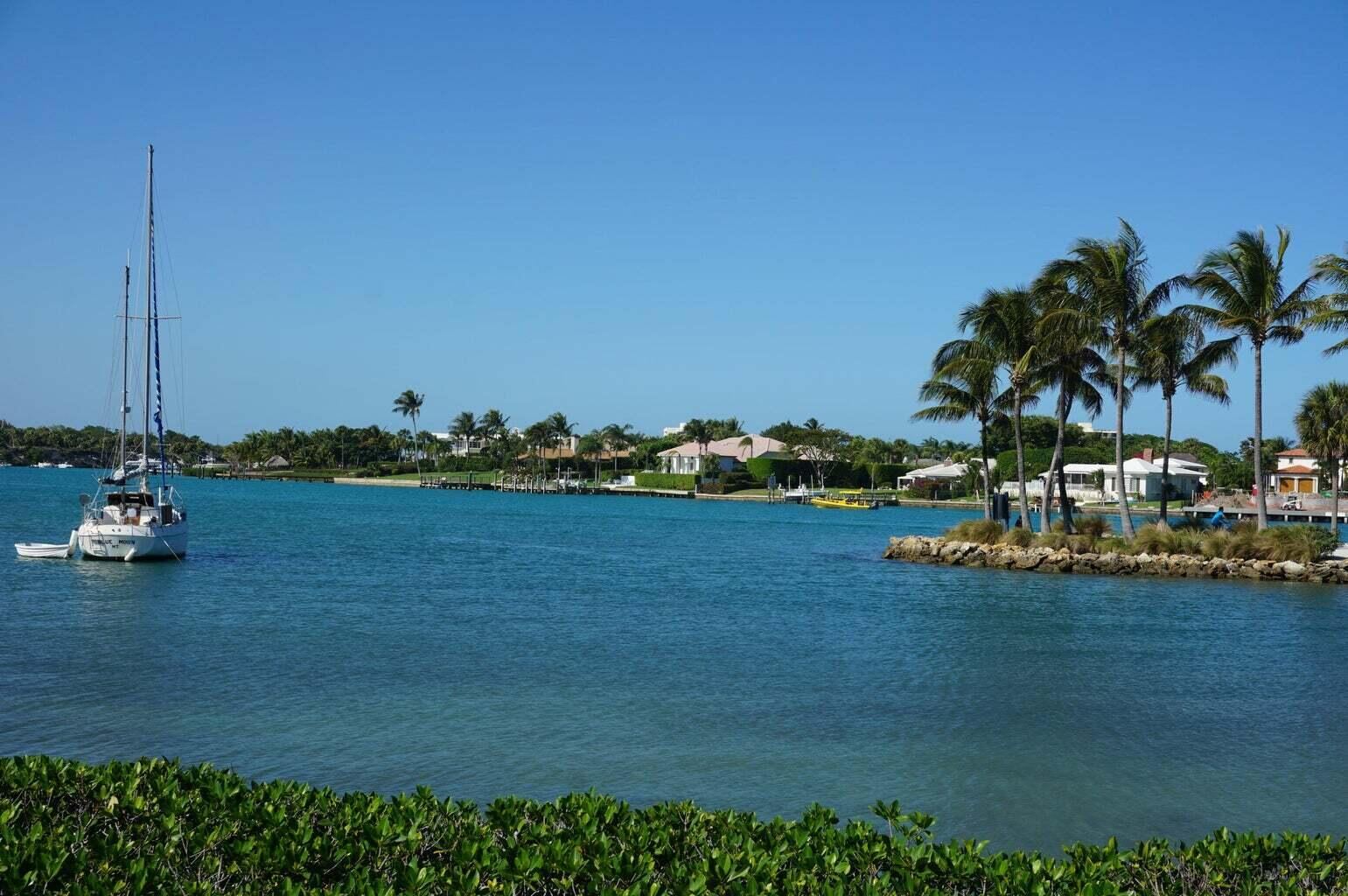 DuBois Park on the Jupiter Inlet, with palms and a sailboat at anchor