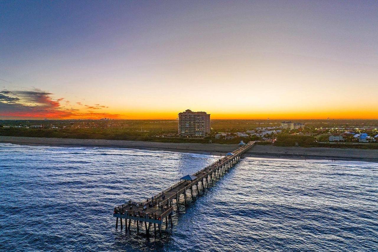 Aerial of Juno Beach Pier at sunset, stretching into the Atlantic